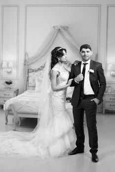 Stylish newlyweds posing for the camera in the apartment