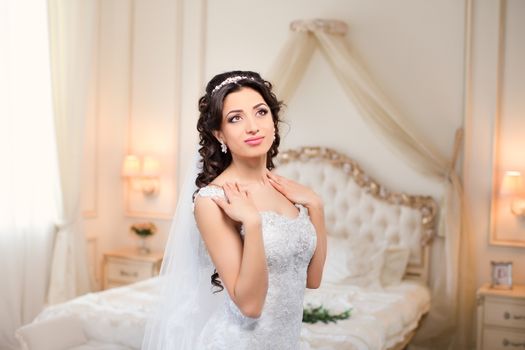 beautiful brunette bride in a luxurious wedding dress posing in interior