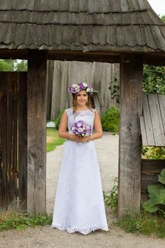 The bride with a bouquet of lilac with wreath
