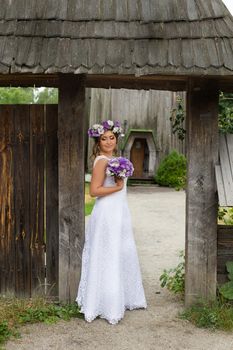 The bride with a bouquet of lilac with wreath