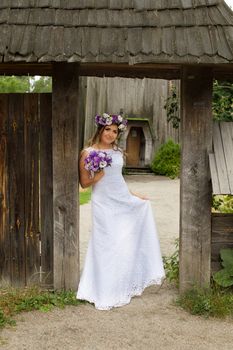 The bride with a bouquet of lilac with wreath