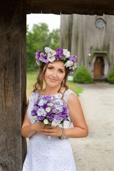 The bride with a bouquet of lilac with wreath