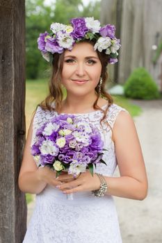 The bride with a bouquet of lilac with wreath