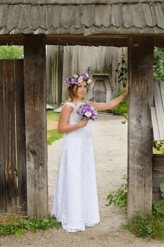 The bride with a bouquet of lilac with wreath