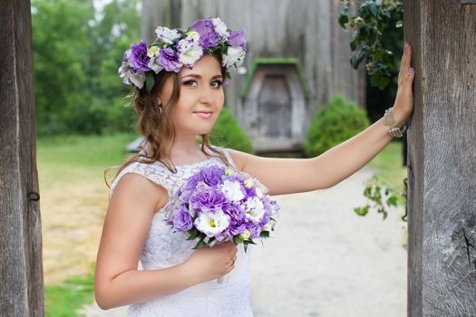 The bride with a bouquet of lilac with wreath