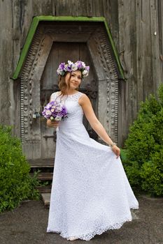 The bride with a bouquet of lilac with wreath