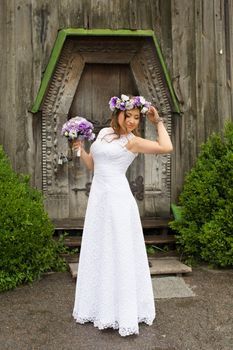 The bride with a bouquet of lilac with wreath