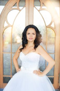 portrait of a brown-eyed sensual kinky girl in white dress on the window background, close up