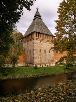 Watchtower monastery in the urban landscape in a warm autumn day on the river