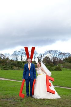 Newlyweds walks away outdoors. Railroad in the forest