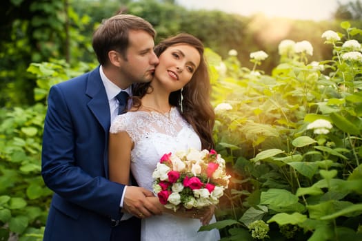 newlyweds in park.newlyweds on walk in the beautiful wood.newlyweds embrace.embraces of newlyweds.newlyweds in the spring wood.gentle.relations.feelings.beautiful groom and bride.fantastic wedding.