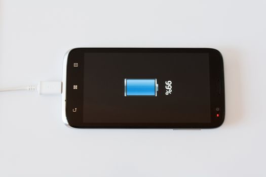 Black Smart Phone Charging with Cable on the white Table