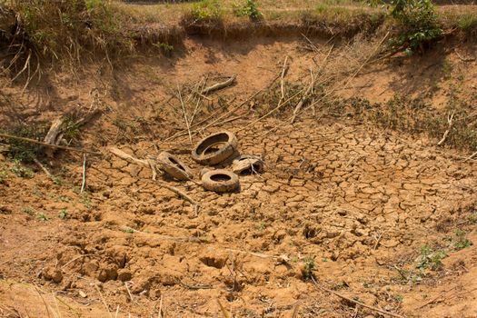 The dry cracked earth in the dried up stream bed of the pond