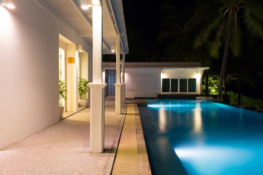 Rear view of luxury villa at night time with swimming pool