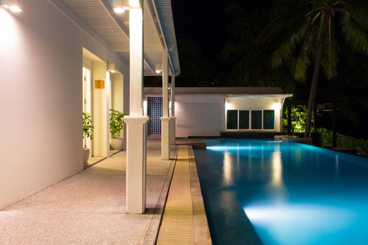 Rear view of luxury villa at night time with swimming pool