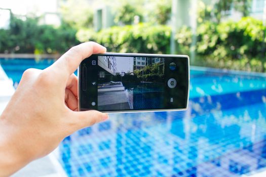 photo shooting on smartphone at swimming pool on holiday time