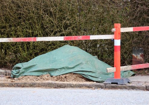 Road work palisade with plastic covered dirt pile