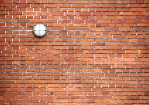 Red brickwall with outdoor lamp and cord