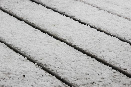 White hail on grey table outside in perspective