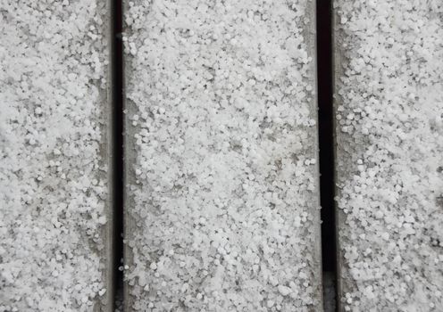 White hail on grey table outside in bird view