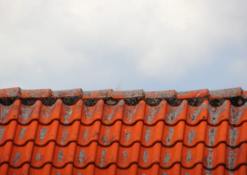 Roof top with red tiles and clouds