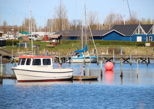 Red marker ball in harbour with ships water and buildings