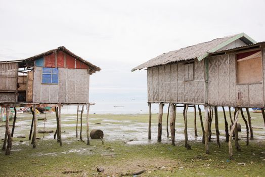 Two fisherman’s cottages on stilts at low tide in the village of Tinito, Maasim, Sarangani Province, The Philippines.