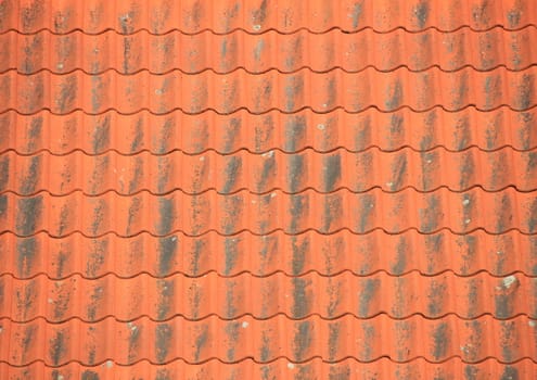 Old red roof tiles with black patina