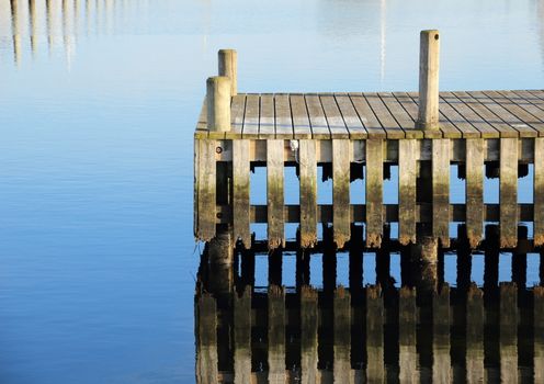 Bathing jetty and landing stage for boats with water reflection