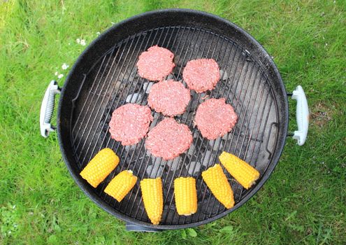 Barbeque grill with beef burger and corncob