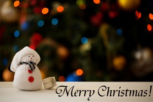 Snowman on a Christmas tree background with inscription Merry Christmas