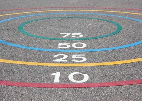 Quoits game with winning circles on asphalt