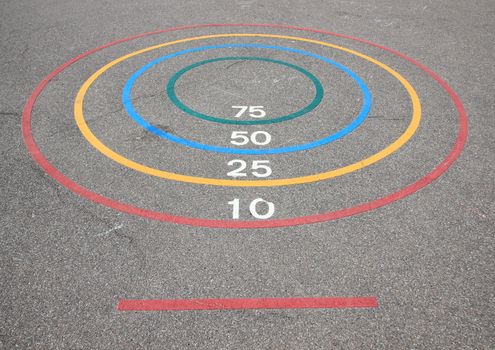 Quoits game with winning circles and baseline on asphalt