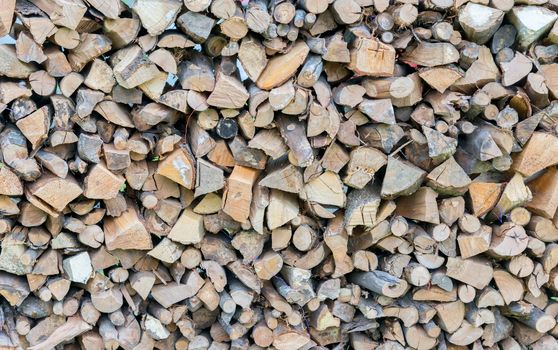 Background of dry chopped firewood logs in a pile