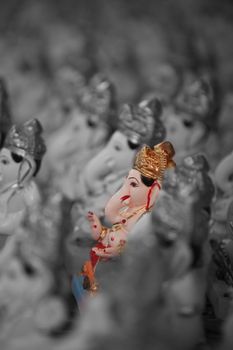 A metaphorical image showing a selected colorful lord Ganesha idol amongst many.