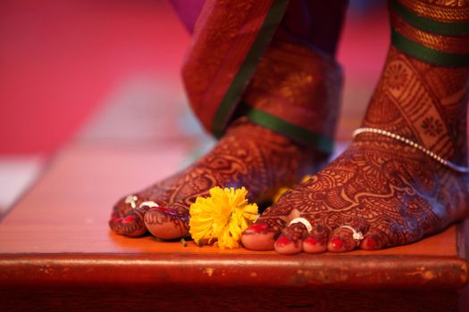 A ritual during a traditional Indian marriage with a marigold flower kept near the brides feet.