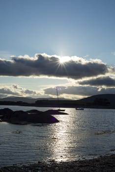 boats in a quiet bay near kenmare on the wild atlantic way ireland with a cold sunset