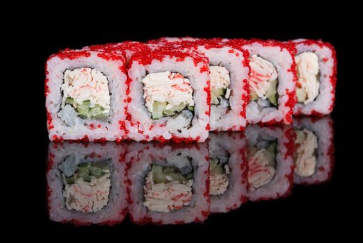 Sushi rolls with crab sticks and cucumber on black background