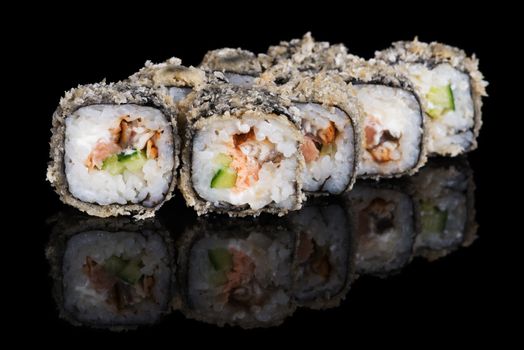 Grilled sushi rolls with salmon and eel on  black background