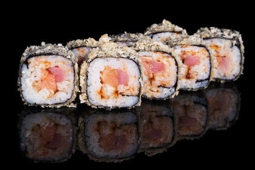 Grilled sushi rolls with fish and sause on  black background