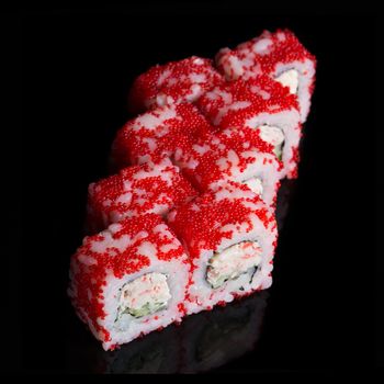 Sushi rolls with crab sticks and cucumber on black background