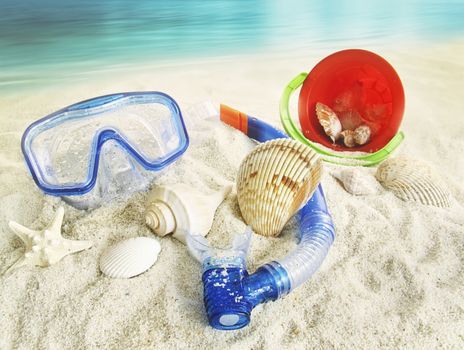 Water goggles and beach toys in the sand