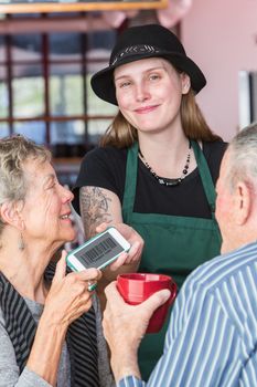 Customer giving barista her phone with barcode coupon on it