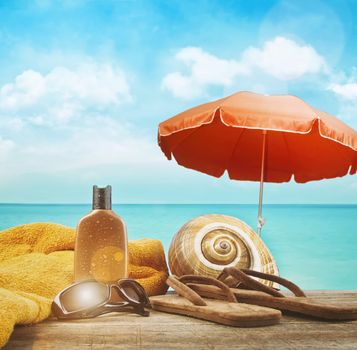 Suntan lotion with towel and sandals at the beach