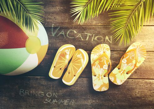 Summer sandals with beach ball on wood background