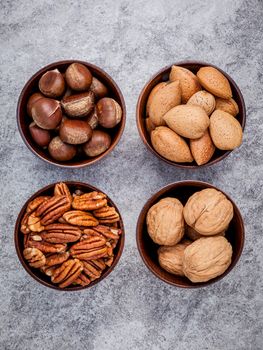 Whole almonds,whole walnuts ,whole hazelnut and pecan nuts in wooden bowl setup with stone background.  