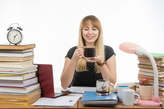 Girl student happily looks at a glass of coffee