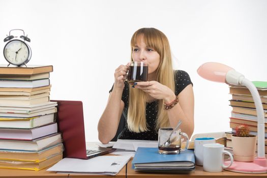 Student drinking coffee by preparing for the exam at night