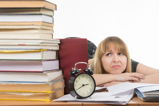 Student with despair looking at a big stack of books