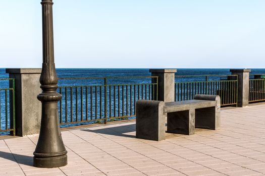 Bench and streetlight at the sicilian sea, Italy.